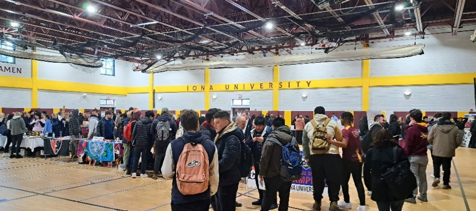 Students walk around tables set up in the Mulcahy Gym for the 2024 Spring Involvement Fair to learn more about clubs and organizations they can get involved with.