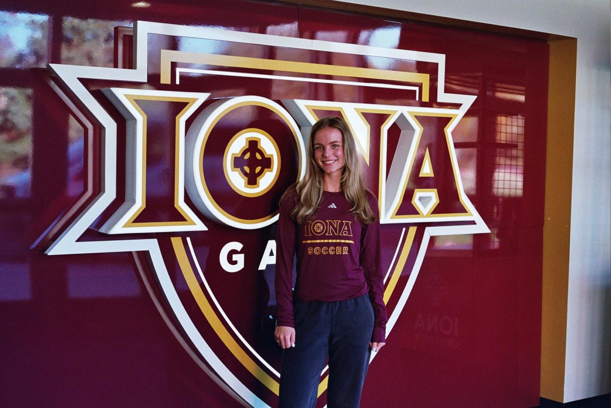 Junior Defender Kara Canetti in front of the Iona logo.